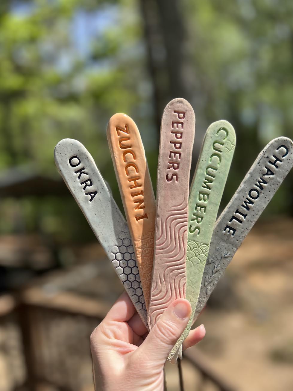 Hand-lettered ceramic garden markers for okra, zucchini, peppers, cucumbers, and chamomile
